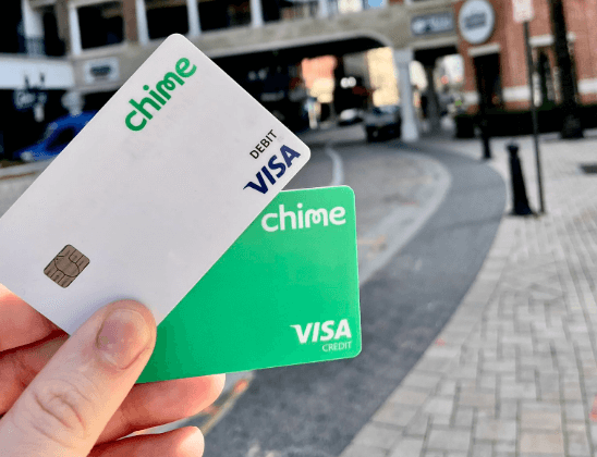 a person holding chime debit and credit card